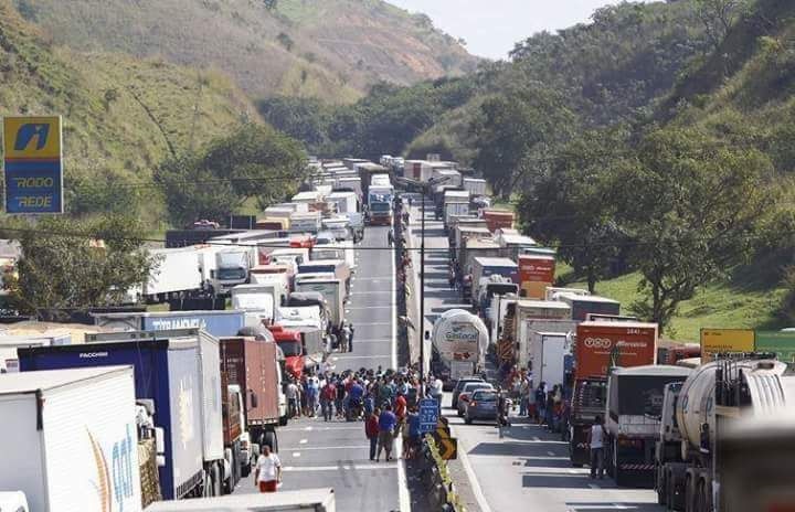 Energy prices have risen, lowering the margins of a key supply chain performer, and that has implications for the container shipping industry. (Above: The scene in May 2018, when Brazil's truckers went on strike, all but freezing road commerical transport.) Photo credit: Rob Ward. Brazil truckers blockade road.