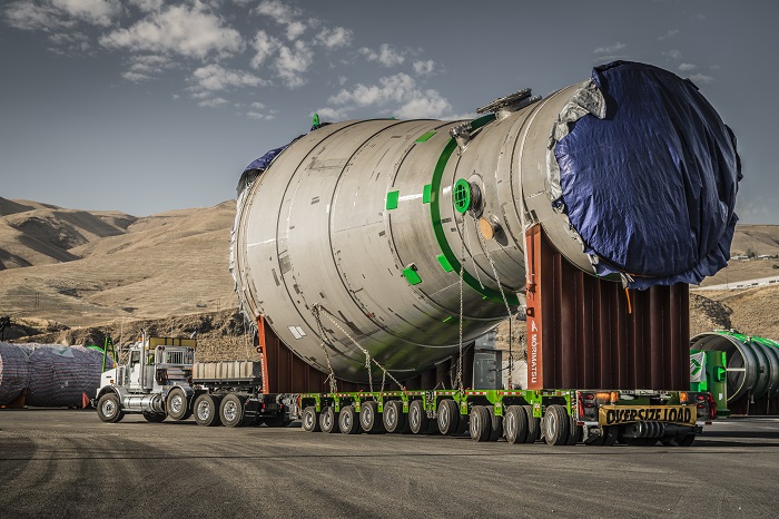 High Wide Heavy Corridor Coalition transporting a large load on a desert road.