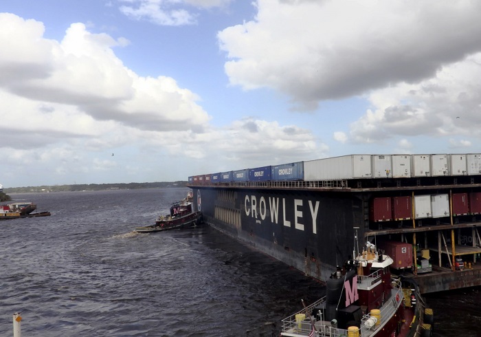 With a quarter of the island’s residents lacking electrical power, long-term improvements are taking a back seat to rebuilding efforts. Photo credit: Crowley Maritime. A barge leaves for a mission.
