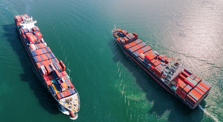 Liner shipping’s current exemption from anti-trust rules ends in 2020 and as part of its assessment of whether to grant another five-year block exemption order, the European Commission (EC) has called for feedback from those in the container supply chain. Photo credit: Shutterstock.com. Two container ships at sea.