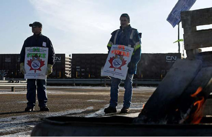 Canadian National Railway employees picket outside a rail facility.