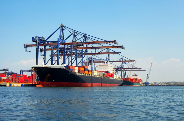 Transshipment is freight transported between an Indian port and an international "hub" port, when direct mainline connections are not available. Photo credit: Shutterstock.com. A container ship at a port.