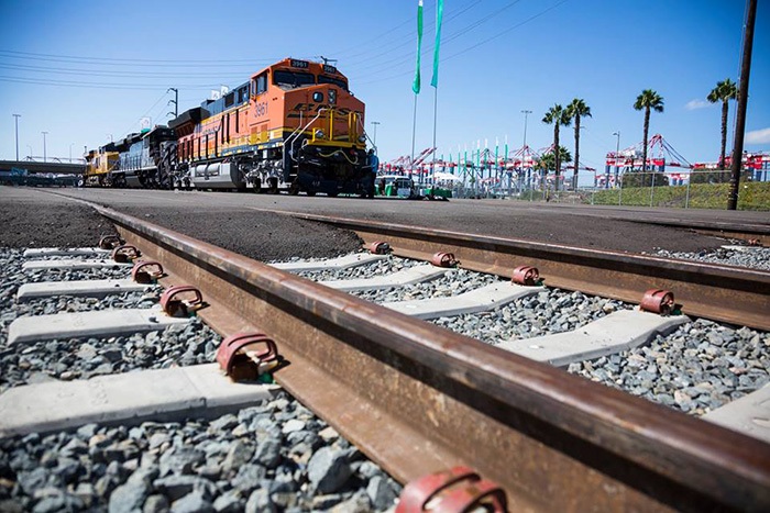 Above: A BNSF train travels near the Port of Long Beach. By improving connectivity in the harbor through more on-dock rail, smoother hand-offs from the vessel to rail, and more timely and accurate data flow, West Coast ports will offer BCOs a more attractive package for shipping discretionary cargo through their gateways to the eastern half of the United States, Los Angeles and Long Beach port executives agree. Photo credit: Shutterstock.com. A BNSF train travels near the Port of Long Beach.