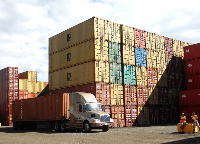 The shippers' group asked the FMC to adopt an interpretative rule to clarify what constitutes “just and reasonable rules and practices” of assessing detention and demurrage upon beneficial cargo owners. Photo credit: Shutterstock.com. A truck and containers at a port.